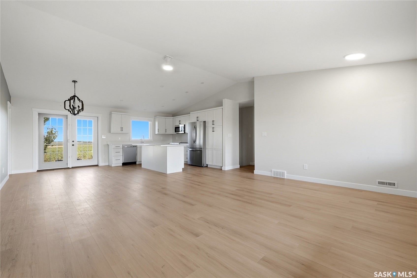 Open-concept living space featuring light wood-finish flooring, white walls, and recessed lighting
