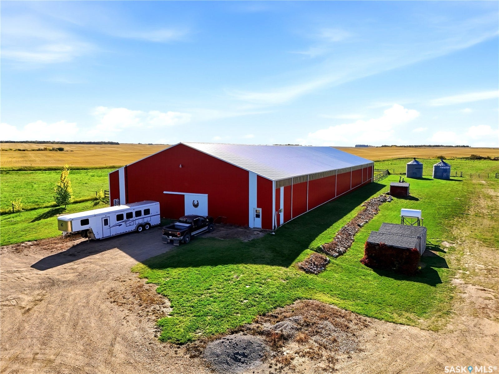 Red metal-sided barn with a white roof, large sliding door, and multiple exterior doors