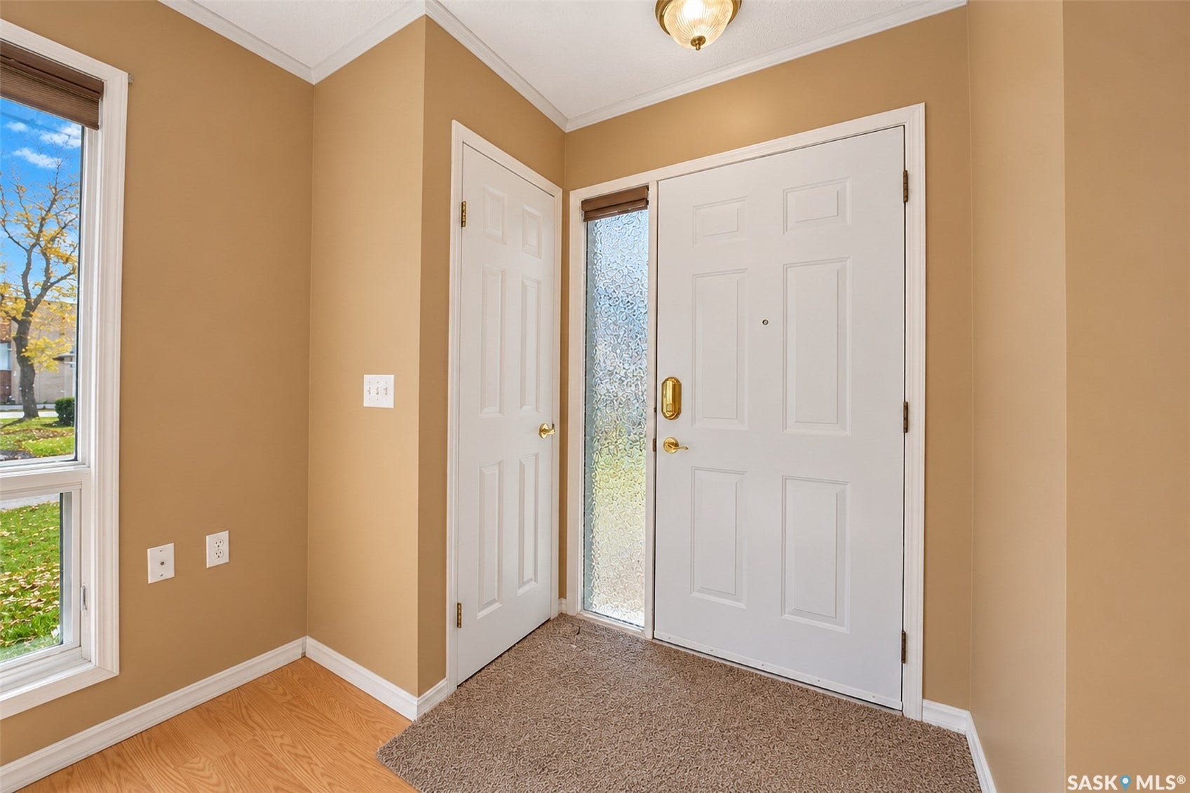 Entryway featuring a paneled door with a sidelight, a double-hung window, and wood-finish flooring