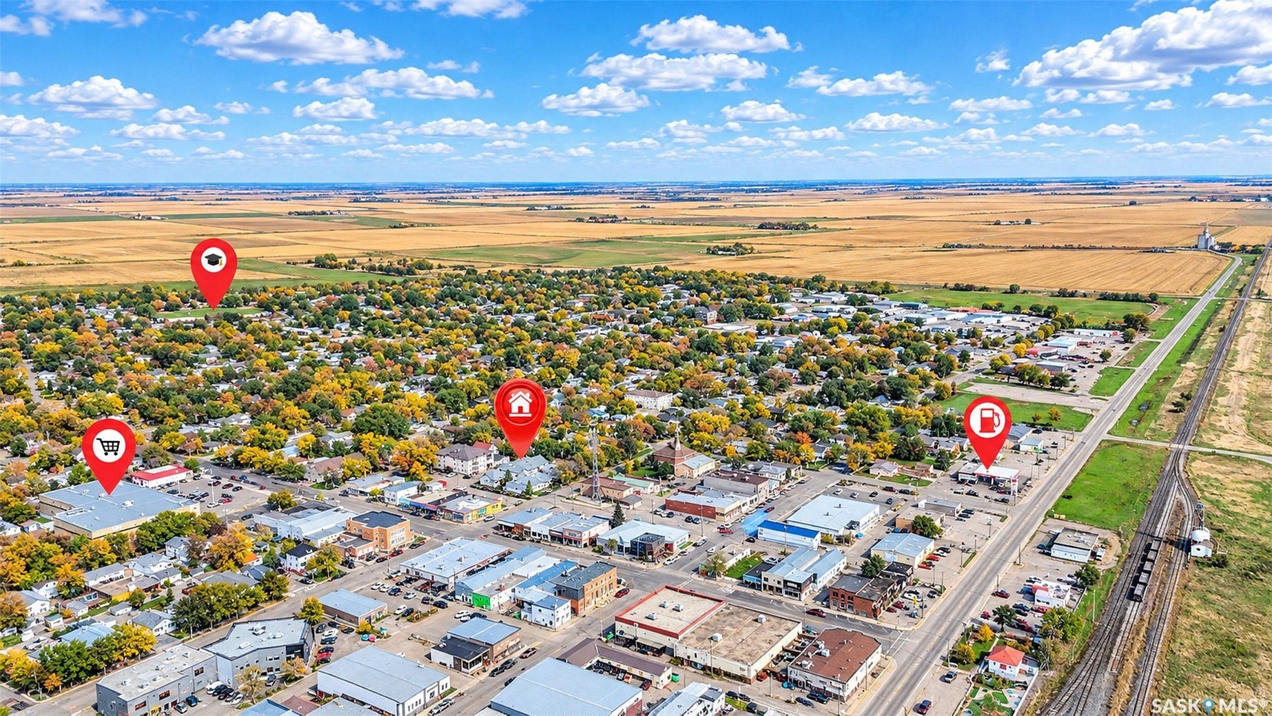 Aerial perspective showcasing a community with established residential areas, commercial buildings, and agricultural fields