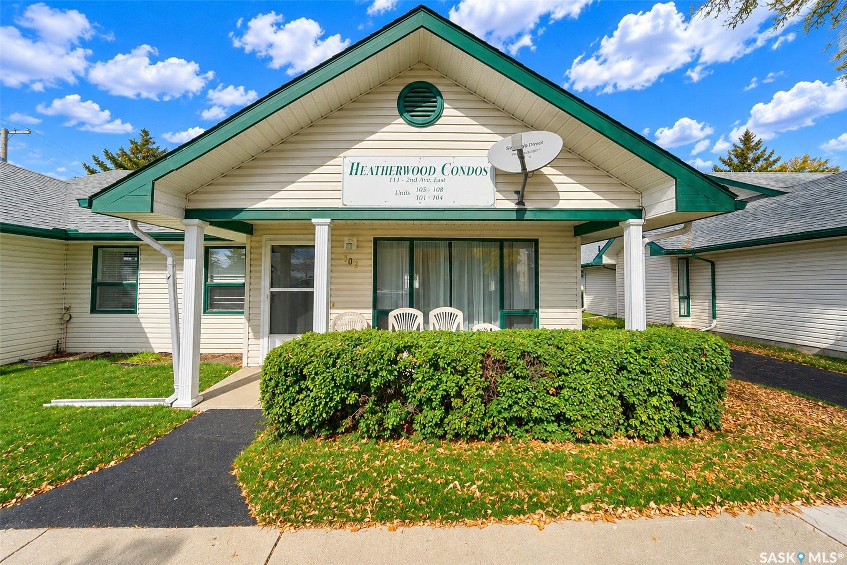 White siding exterior with green trim, gabled roofline, and covered entry