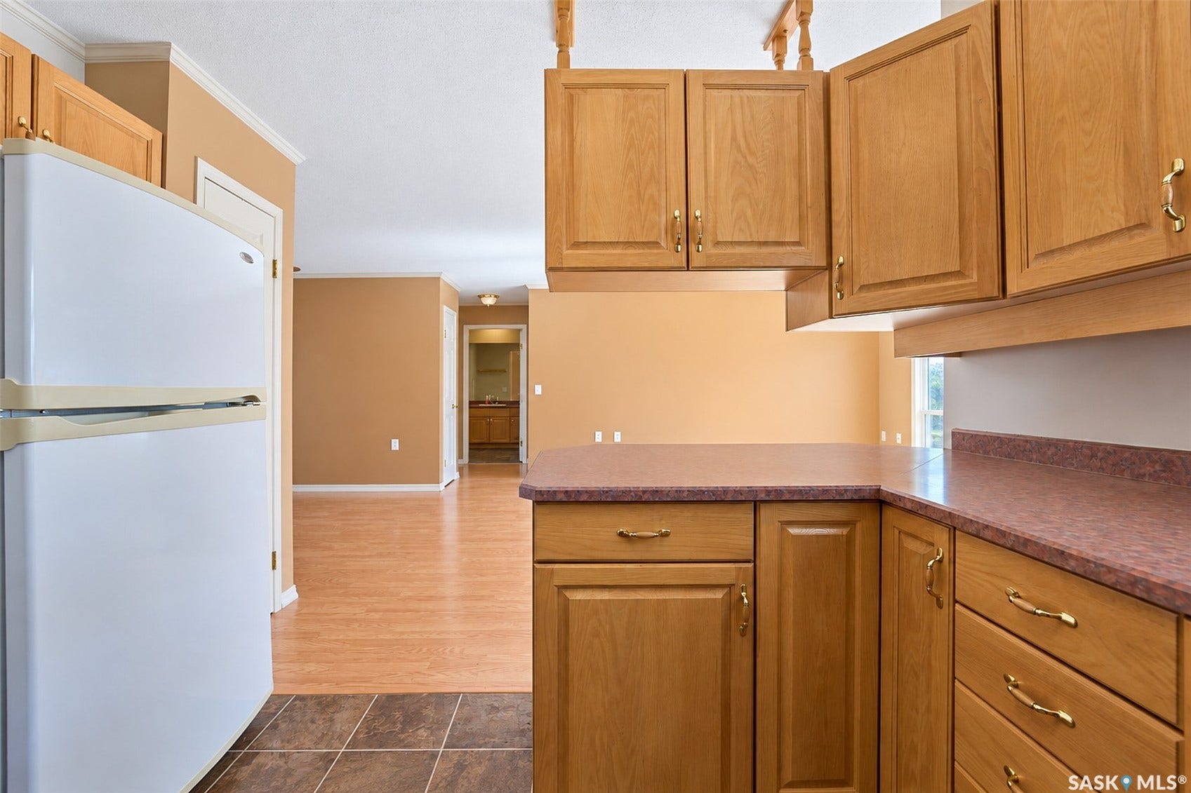 Kitchen featuring wood cabinetry, laminate countertops, and tile flooring