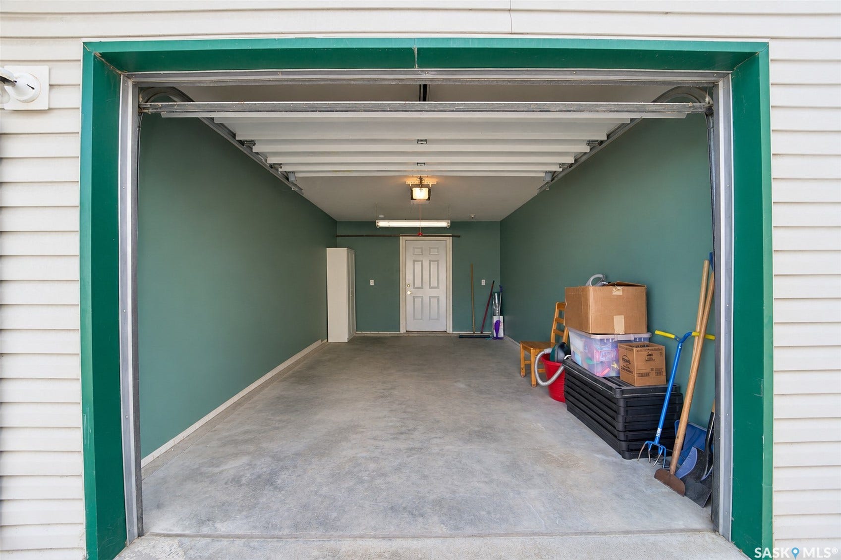 Concrete flooring, painted walls, overhead lighting, interior door