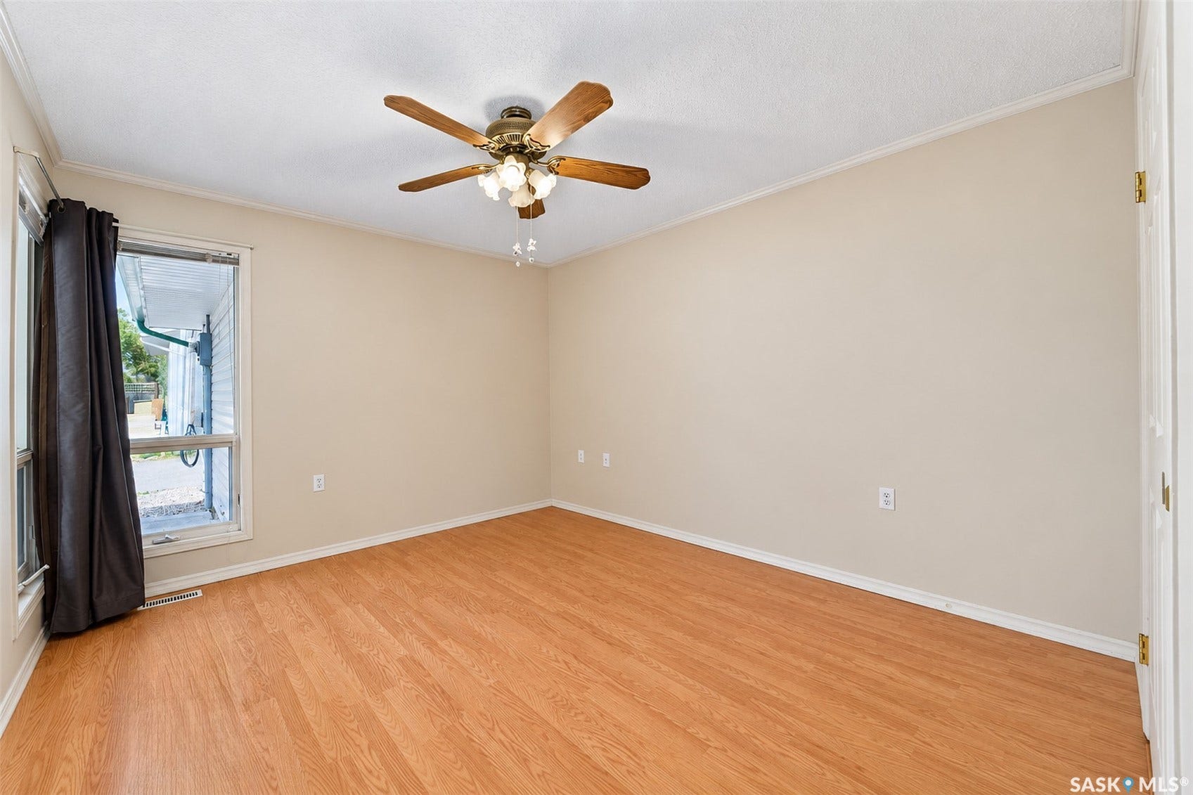 Wood-finish flooring with a ceiling fan light fixture and neutral wall tones