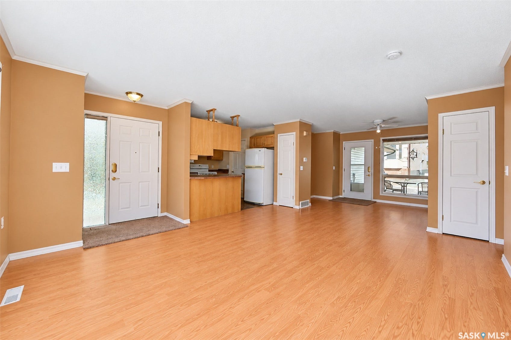 Wood-finish flooring throughout, light wood cabinetry, and white trim