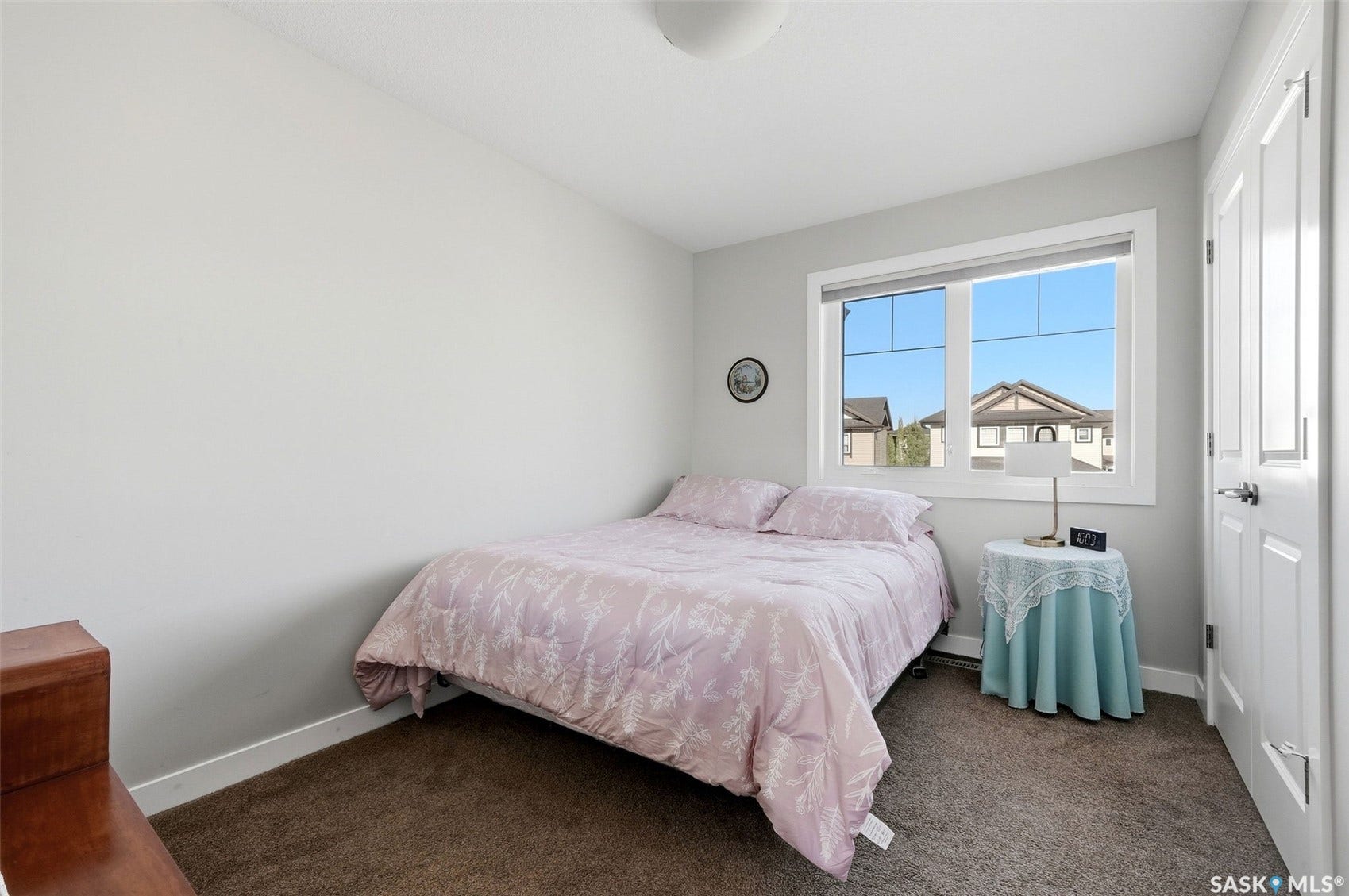 Neutral paint palette, window with white trim, white door, and brown carpet