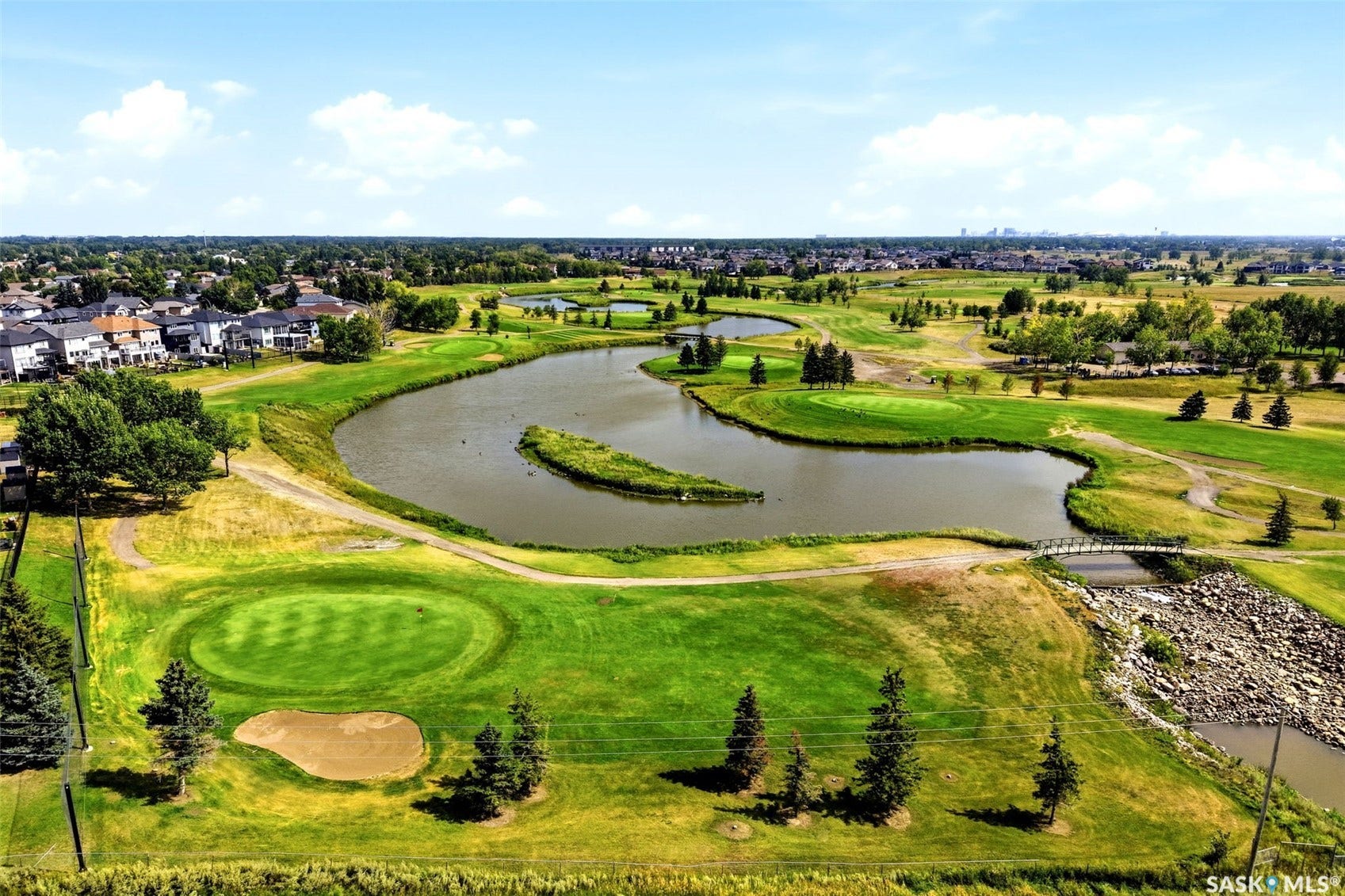 Expansive golf course setting featuring multiple greens, water features, and manicured landscaping