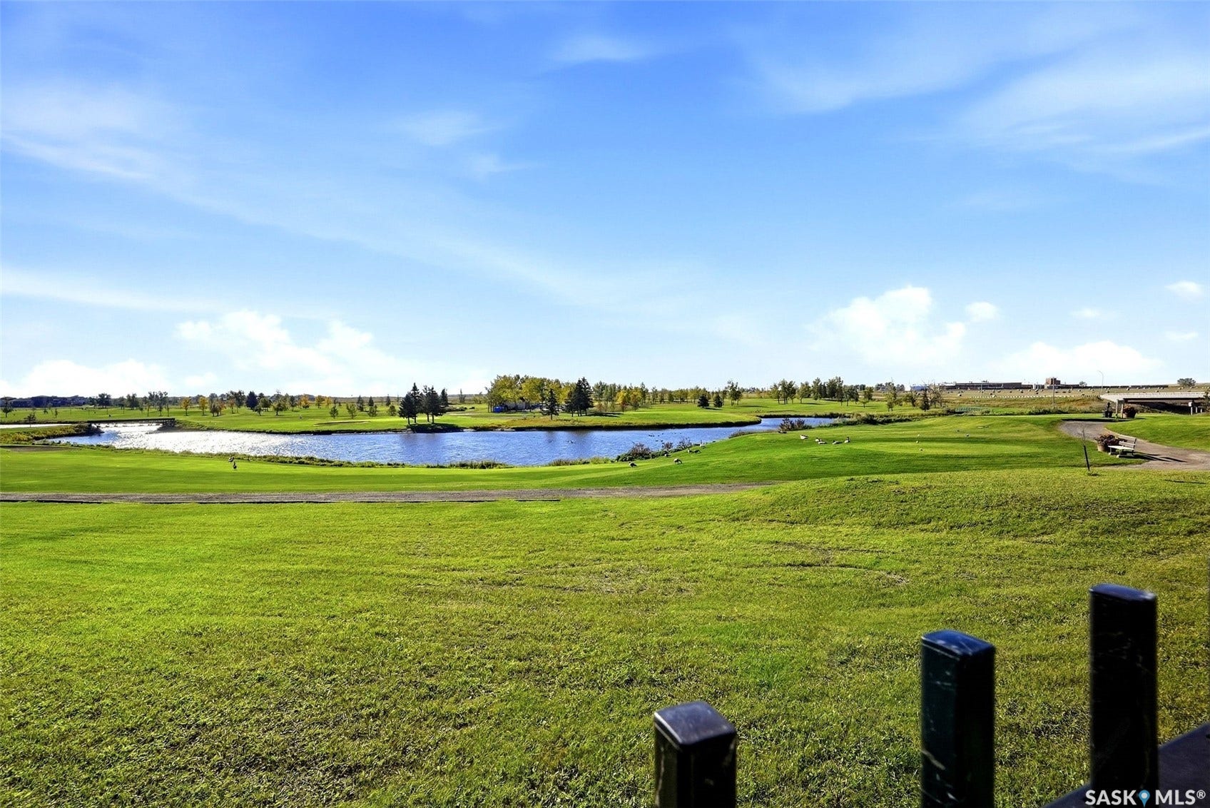 Expansive green spaces with multiple bodies of water and mature trees