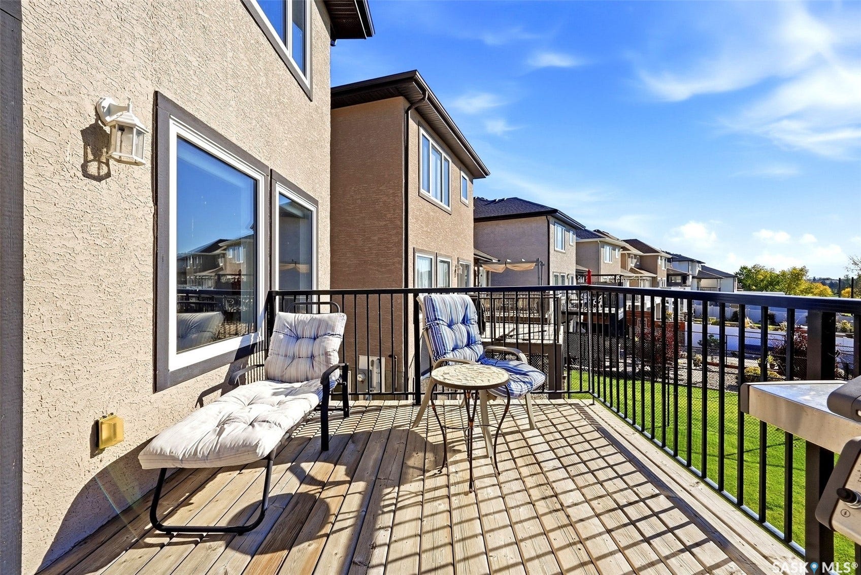 Expansive rear deck featuring wood-finish flooring and black metal railings