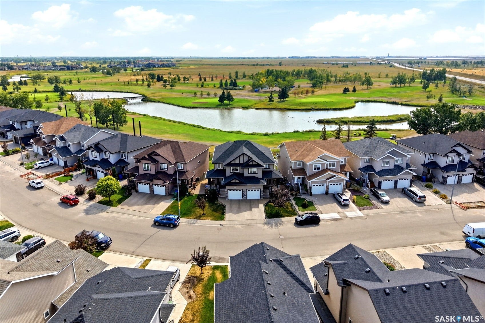 Residential street featuring multiple properties with attached garages and paved driveways
