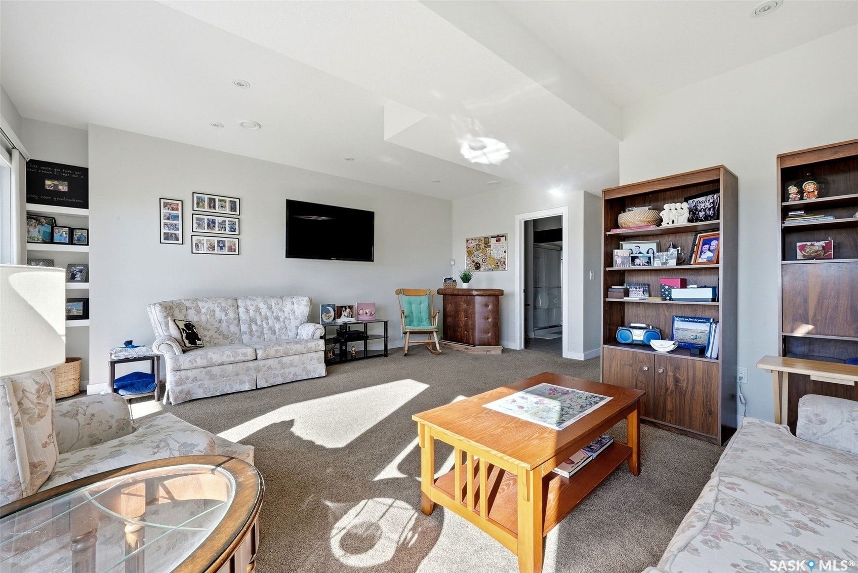 Recessed lighting, built-in shelving, carpet flooring, and a solid core door
