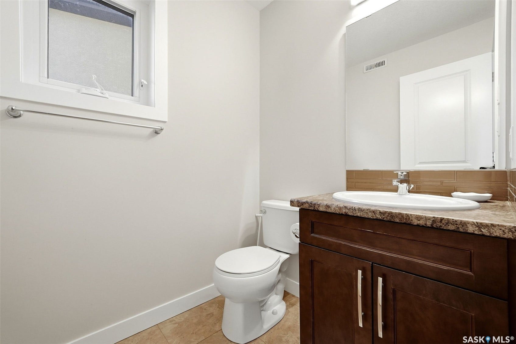 Dark wood-finish vanity with a surface-mount sink, brown patterned countertop, and a tiled backsplash
