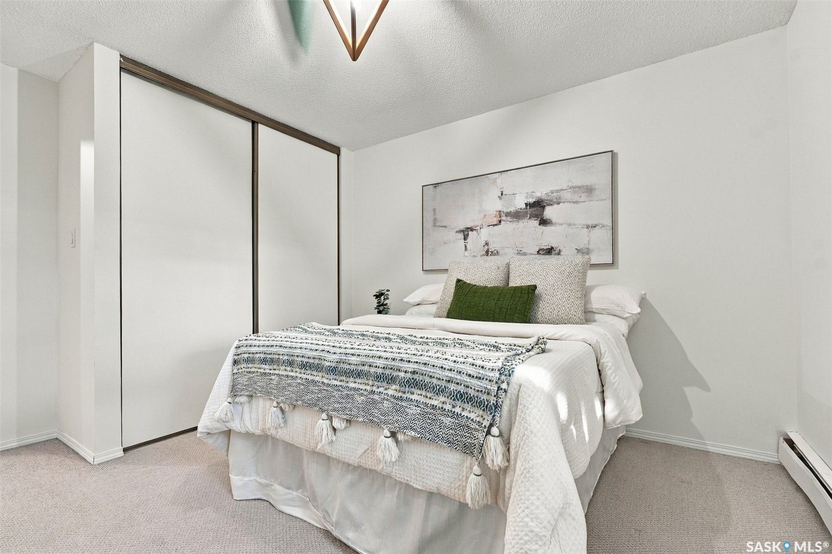 Integrated sliding closet doors with dark wood-finish trim, neutral wall color, and light-toned carpet