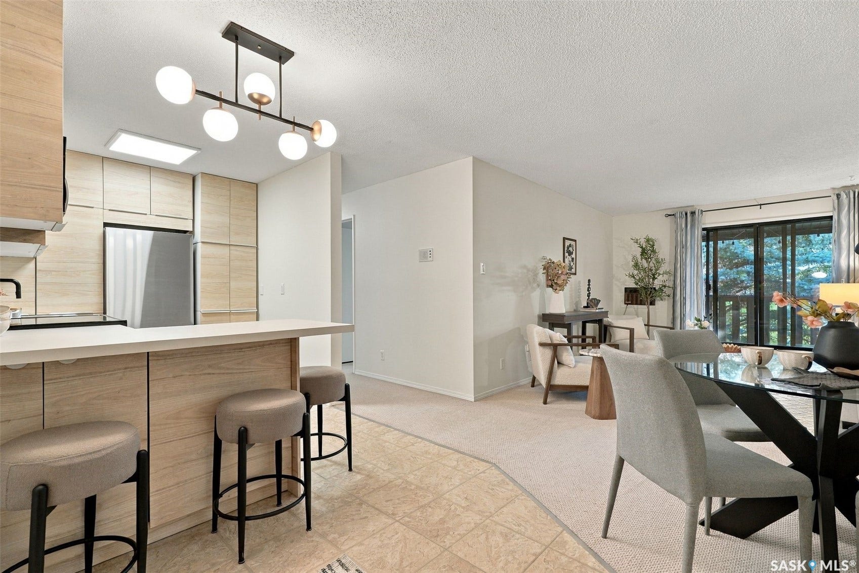 Open-concept living space with a kitchen island, recessed lighting, and a sliding glass door