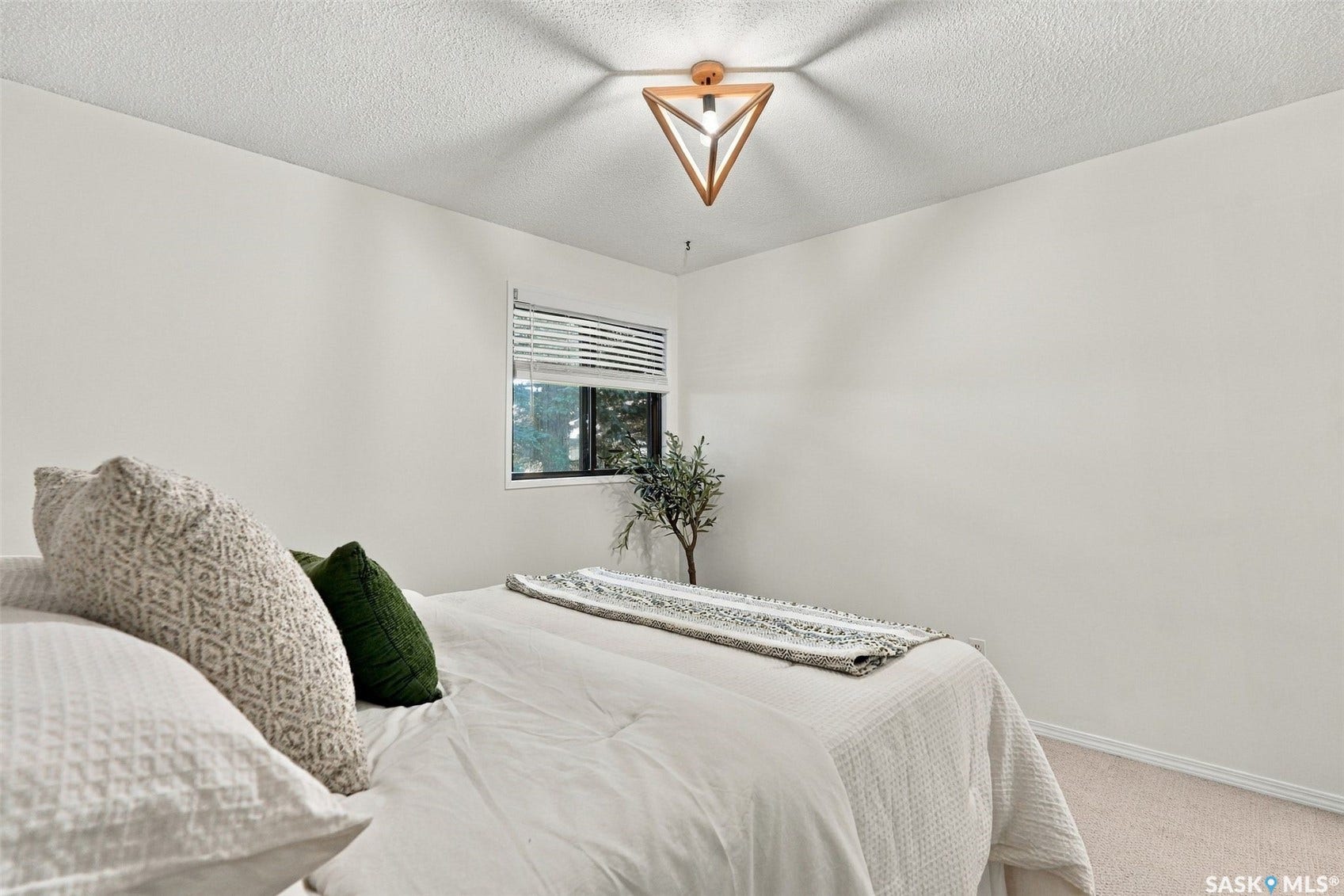 Recessed window with horizontal blinds, carpeted flooring, and a unique geometric flush mount ceiling light fixture