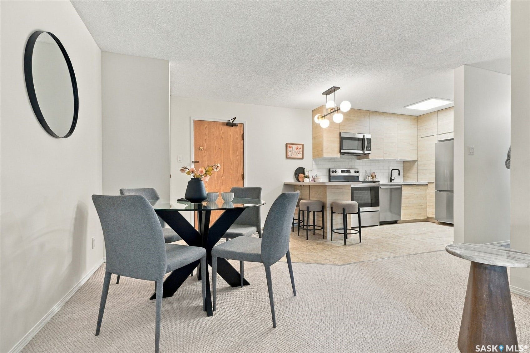Kitchen featuring light wood-finish cabinetry, stainless steel appliances, and a breakfast bar with built-in seating