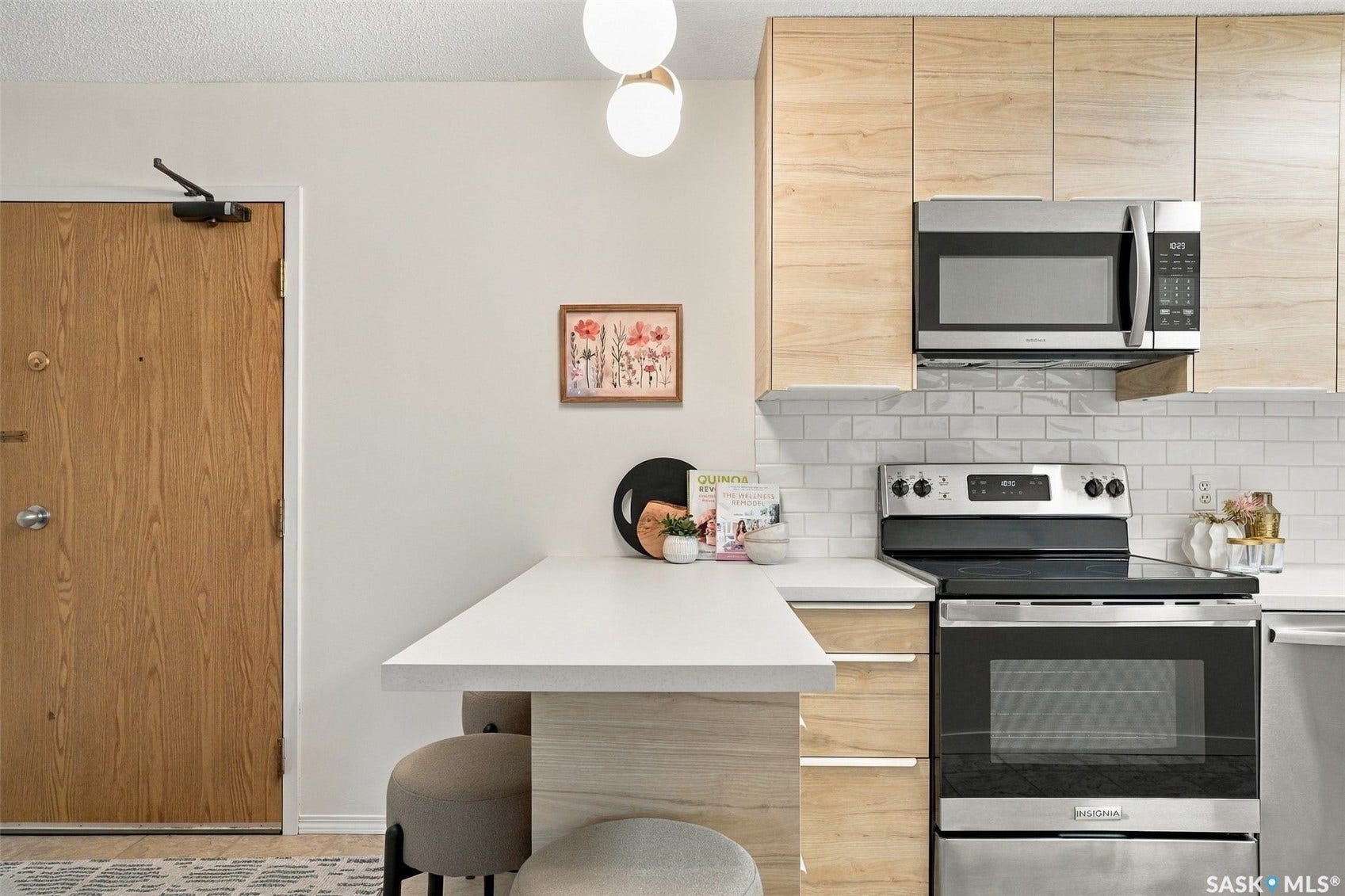 Contemporary kitchen featuring wood-finish cabinetry, stainless steel appliances, a subway tile backsplash, and white countertops