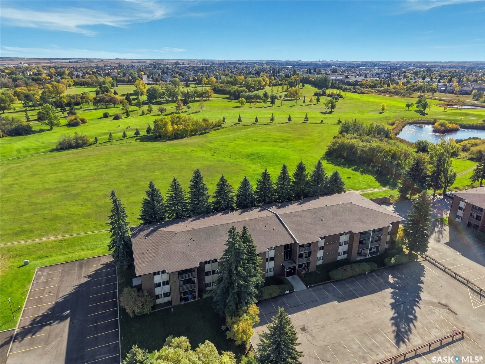 Expansive green spaces and landscaping, with a prominent pond feature