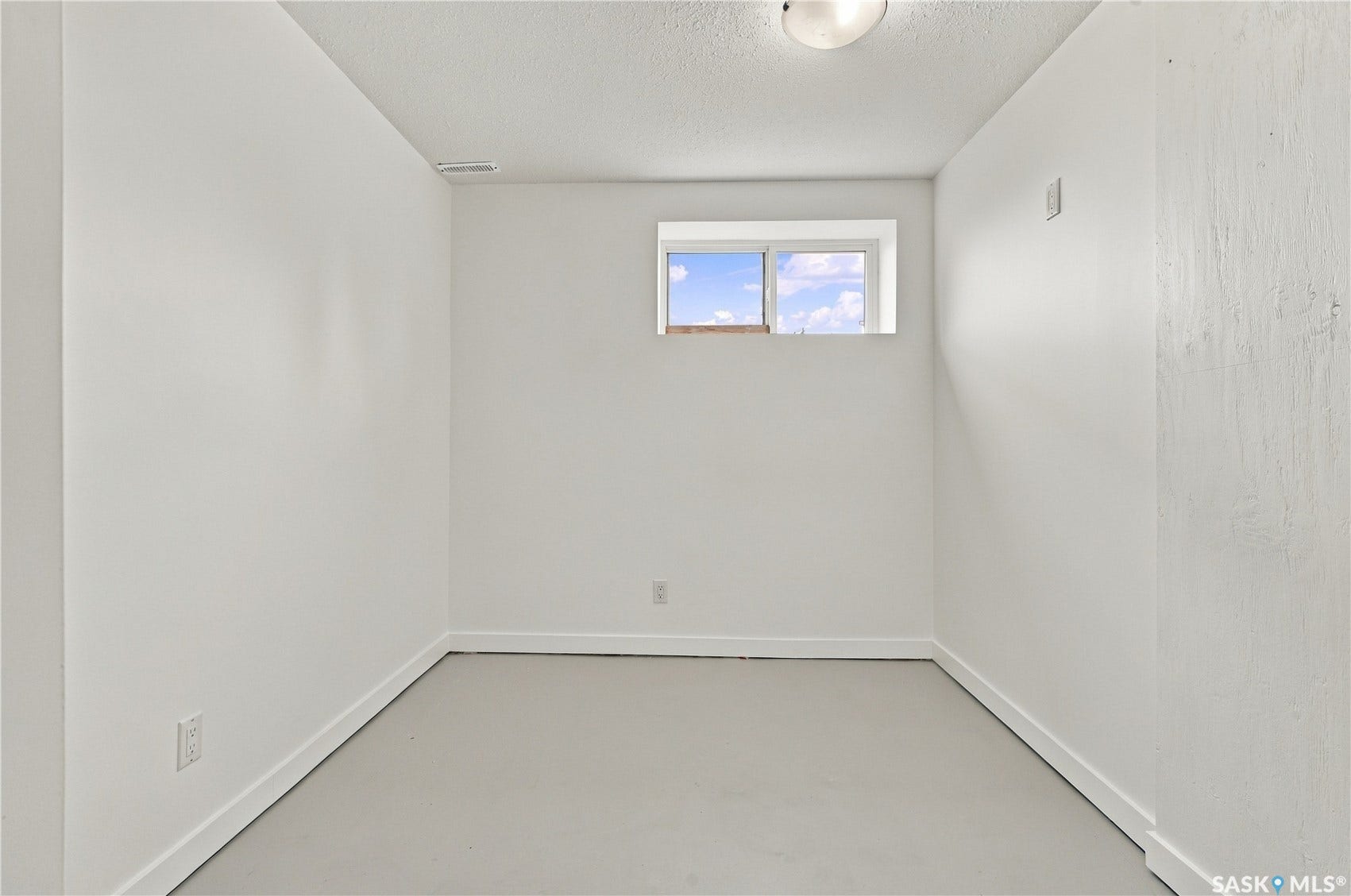 Recessed window with natural light, neutral wall finishes, and ceiling-mounted light fixture