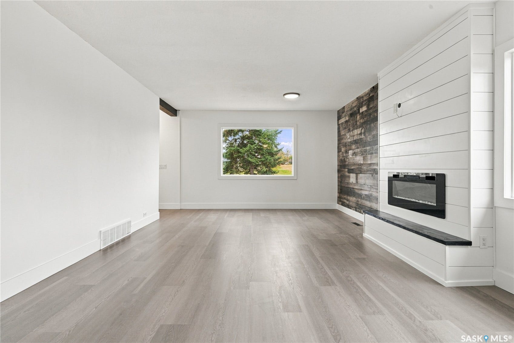 Light wood-finish flooring, recessed lighting, and a window with exterior scenery