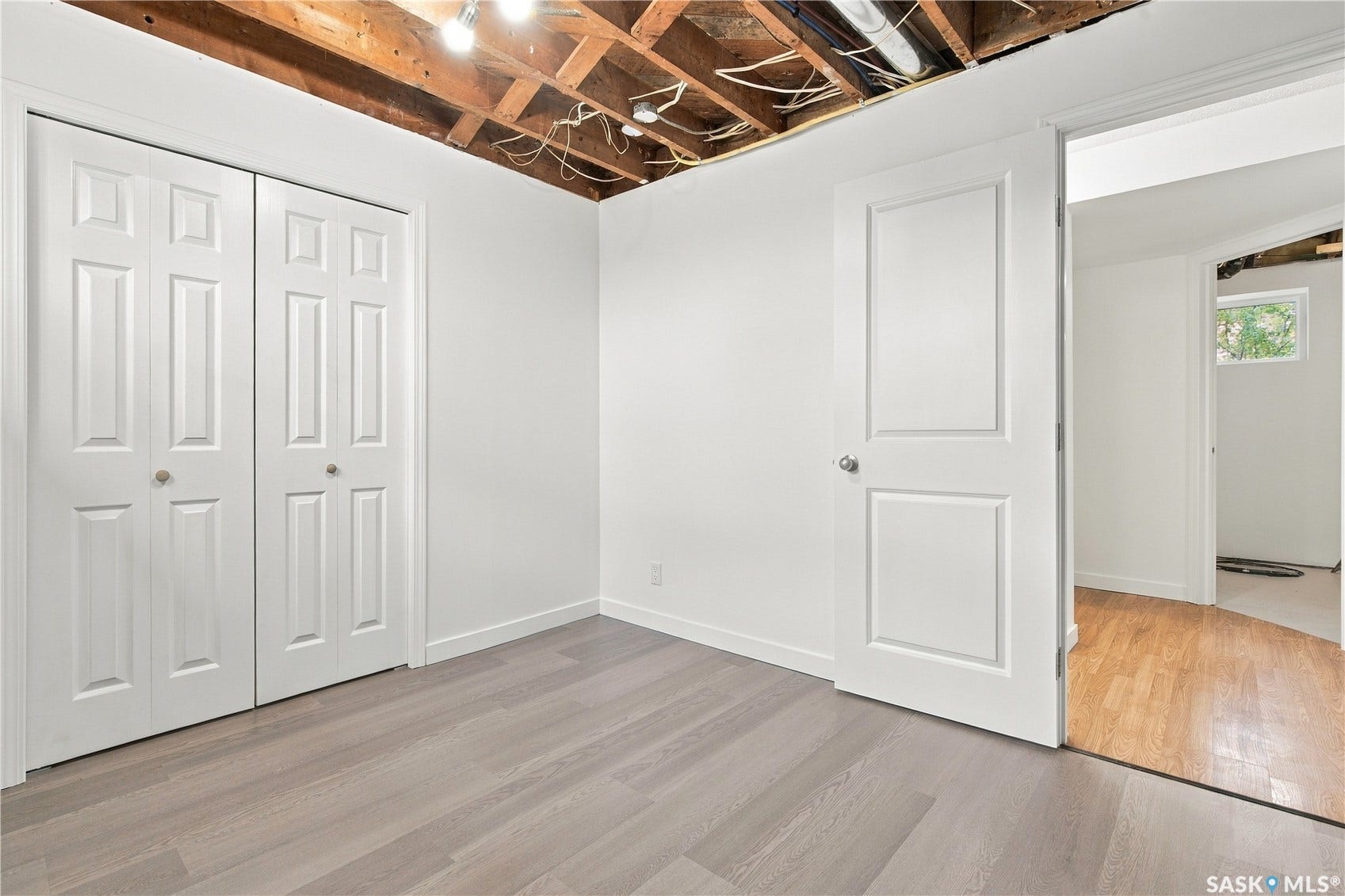 Light gray wood-finish flooring, crisp white walls, and bright overhead lighting