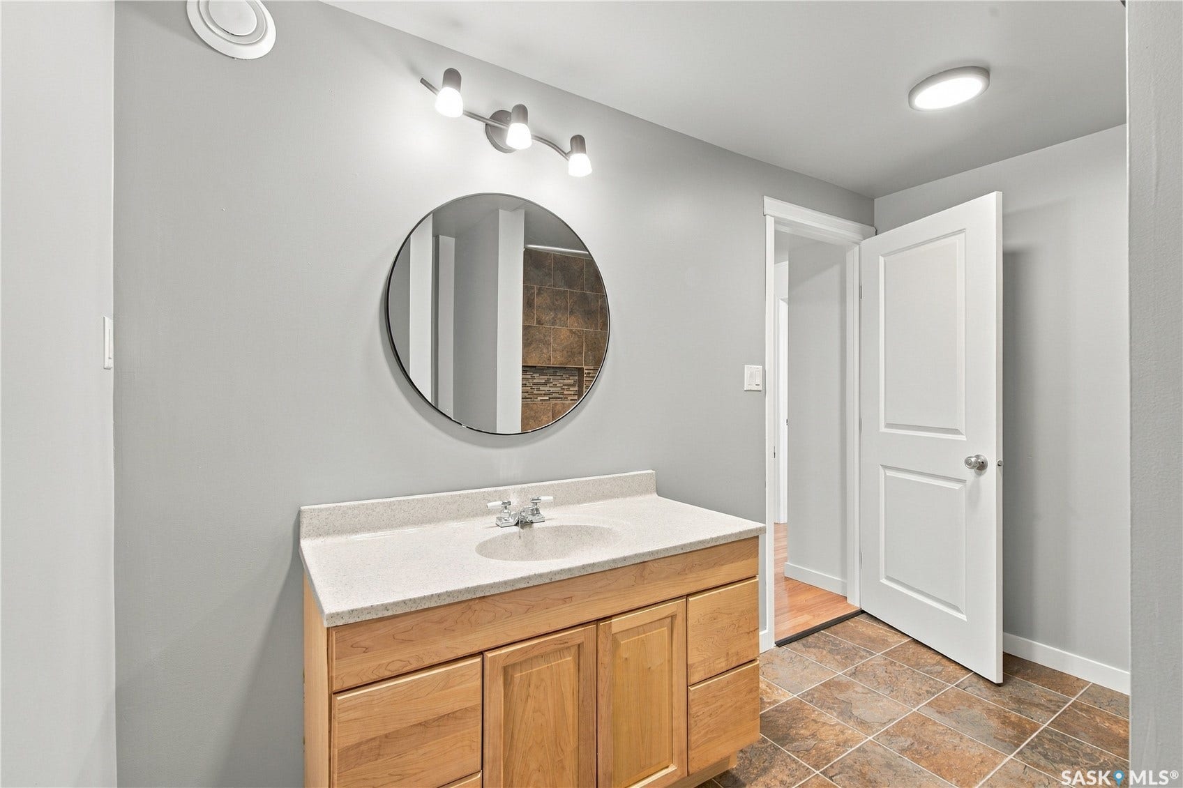 Wood-finish vanity with a light-toned countertop and an undermount sink