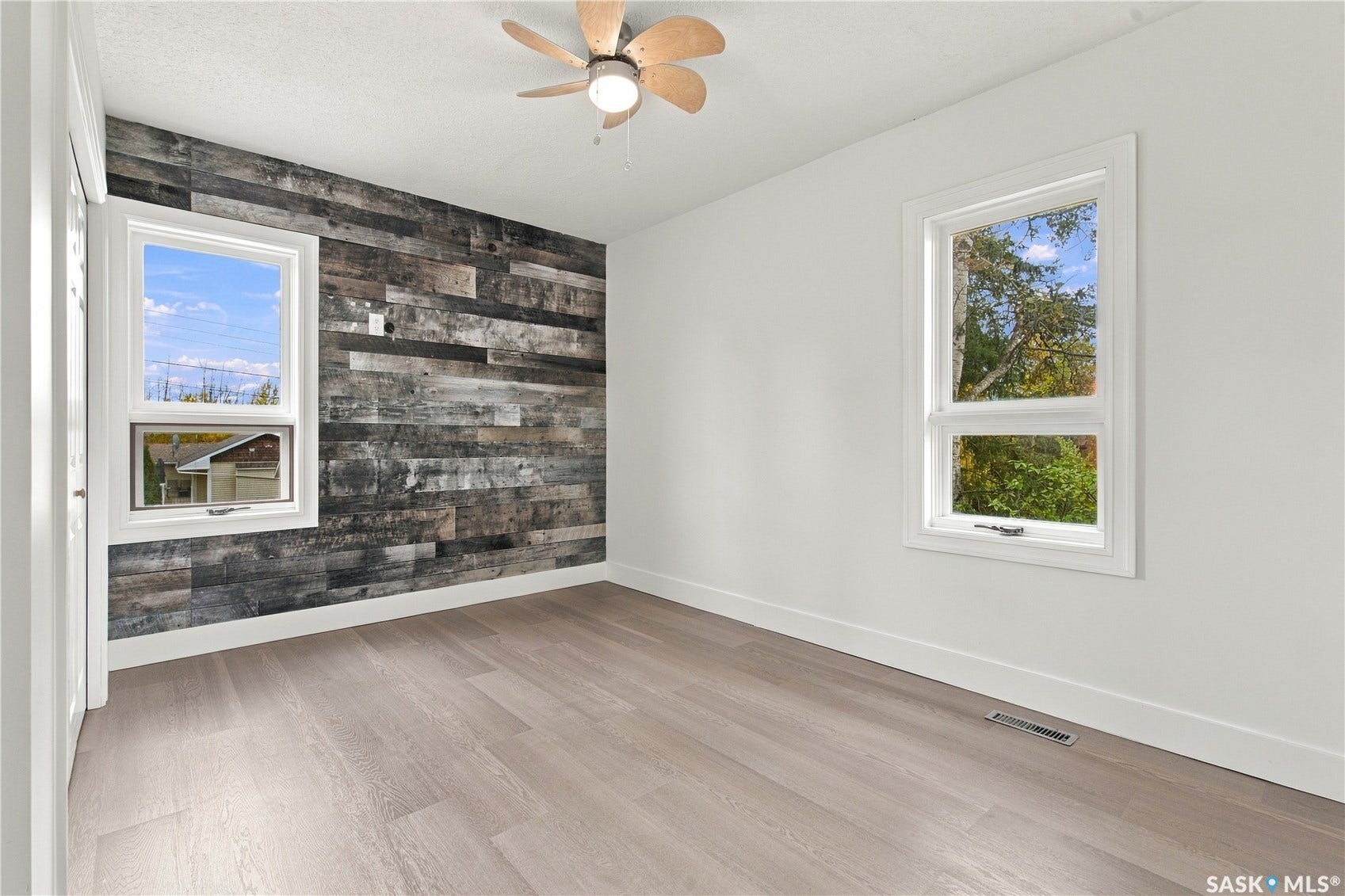 Light wood-finish flooring with white baseboards