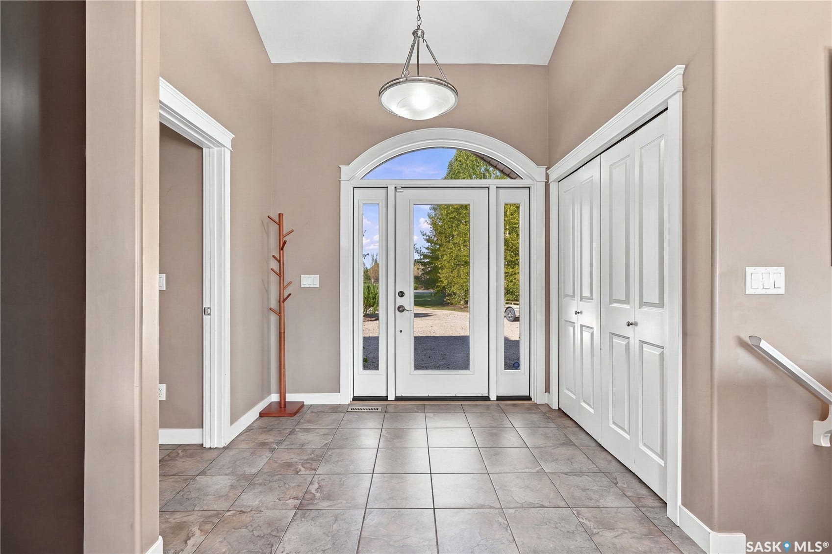 large welcoming front entry with large closet with convenient direct access to the mudroom/laundry area and 2 piece bathroom and attached triple garage
