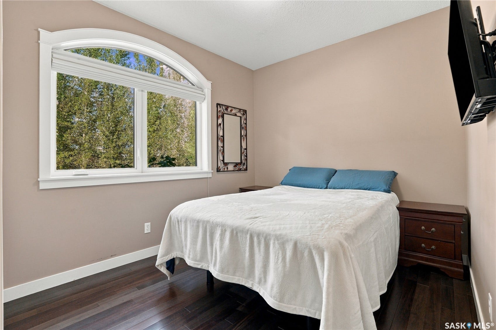 2nd bedroom on main level with closet and window with views of yard and trees