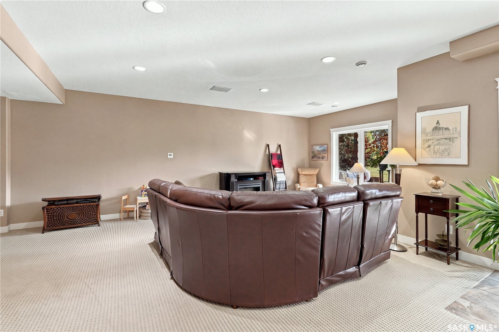 lower level living room area with large south facing windows with open views to yard and nature