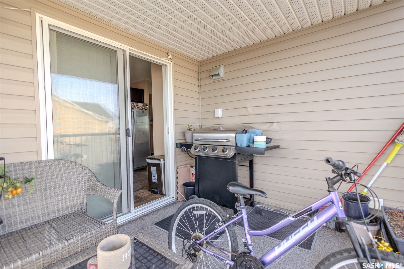Patio area featuring durable siding, a sliding glass door, and a textured floor surface