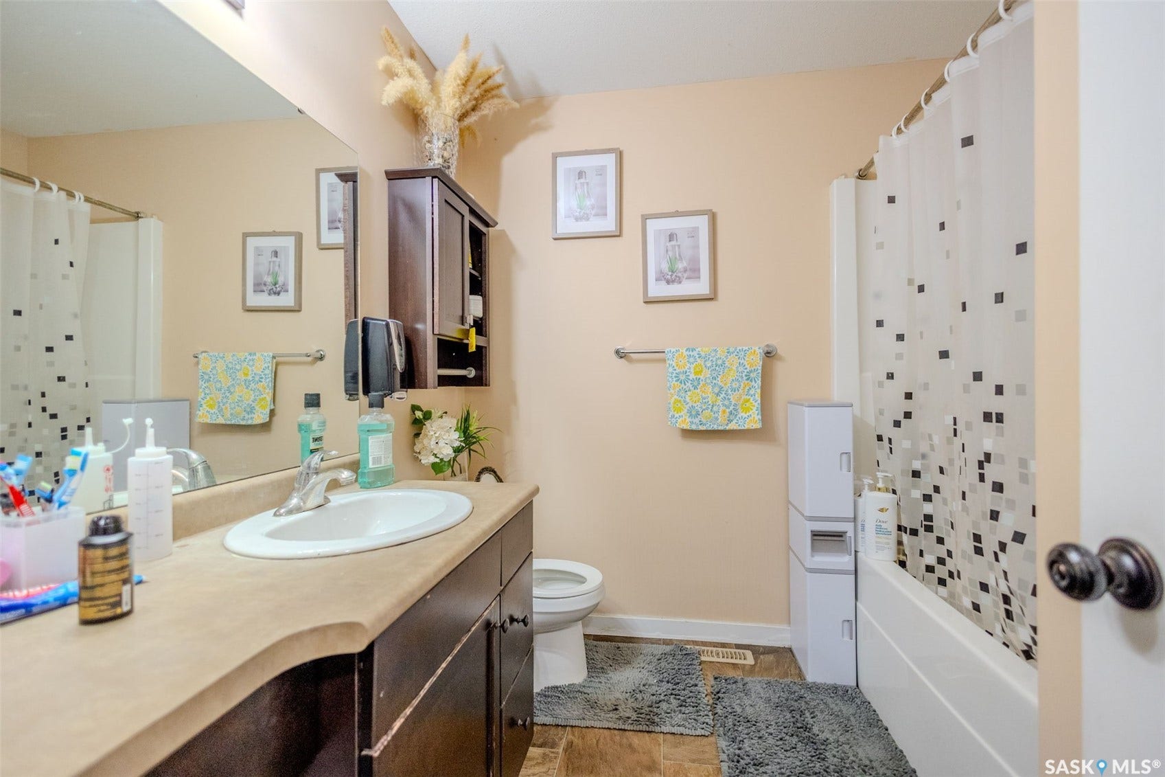Bathroom featuring a vanity with a countertop, an undermount sink, a wall-mounted medicine cabinet, and a shower-tub combination