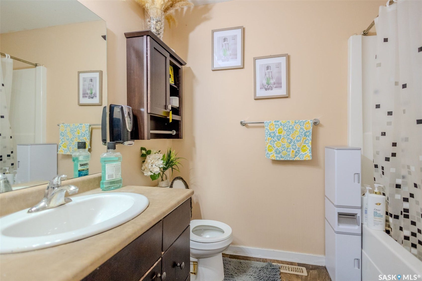 Spa-inspired bathroom featuring a curved vanity with integrated sink, wood-finish cabinetry, and ample counter space