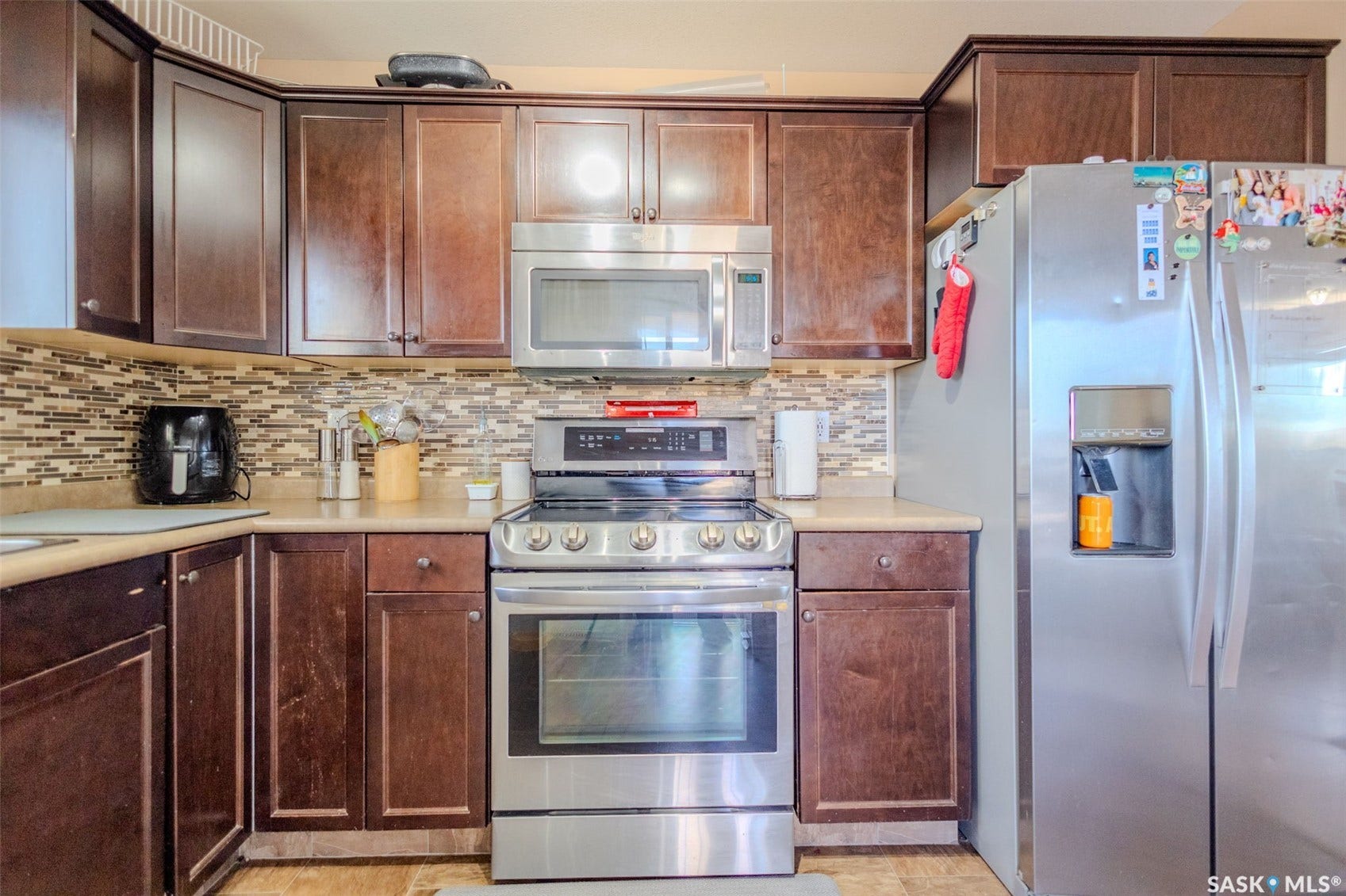 Dark wood-finish cabinetry complemented by a mosaic tile backsplash