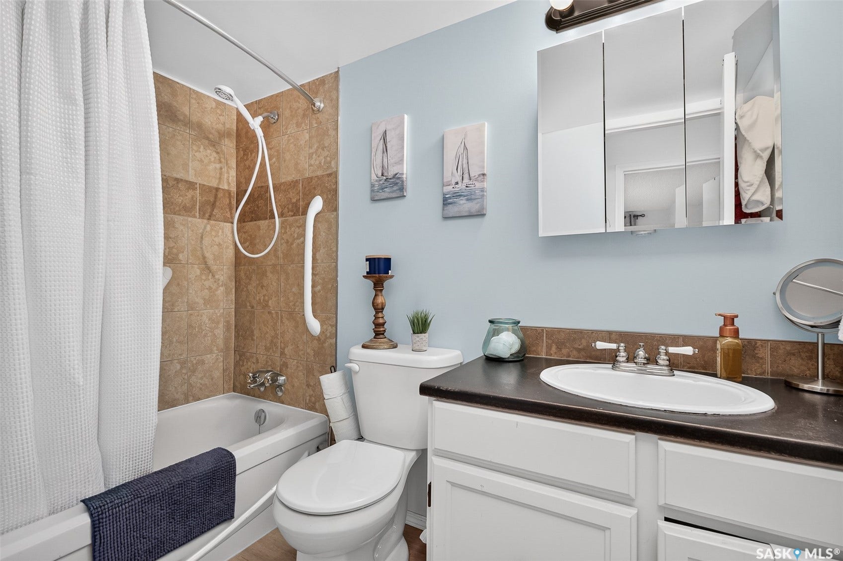 Built-in bathtub with tiled surround, wall-mounted showerhead, and grab bar