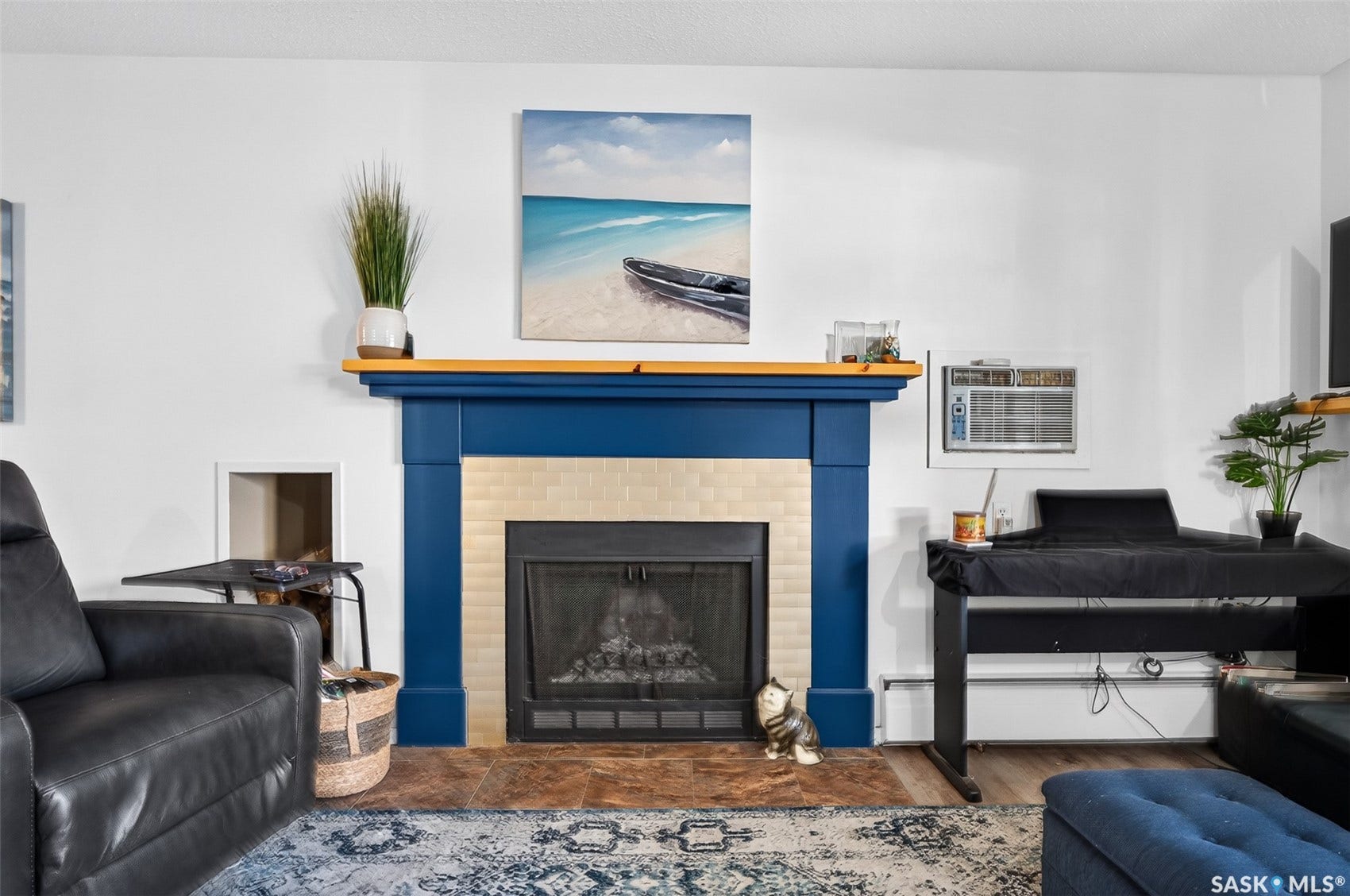 Fireplace featuring a blue mantel with a wooden top, light-colored tile surround, and a dark hearth