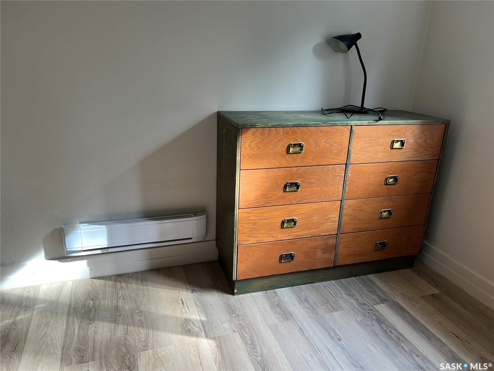 Wood-finish flooring with a wall-mounted heating unit