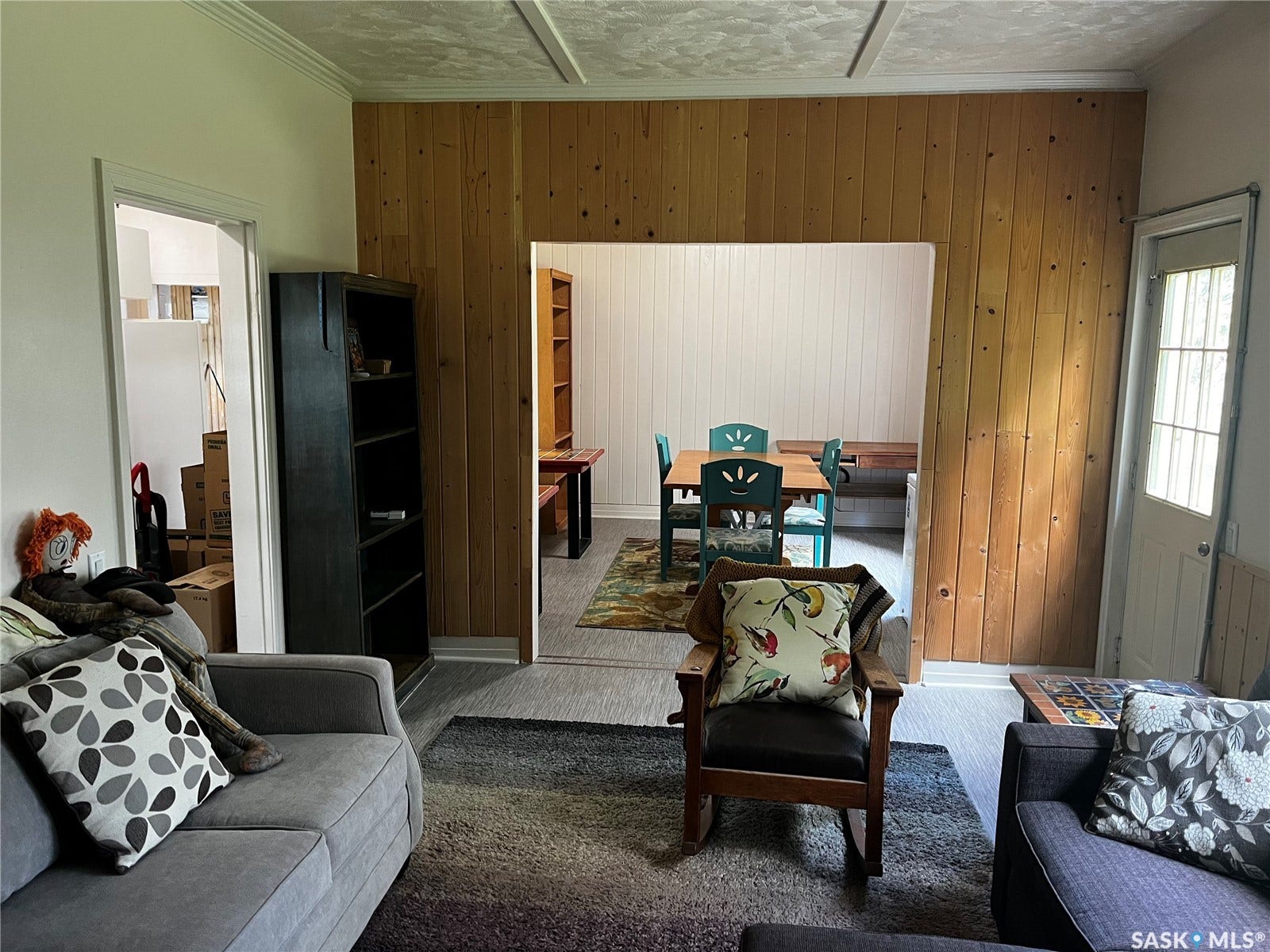Wood-paneled accent wall, neutral wall paint, white trim, recessed doorway opening, and wood-finish flooring