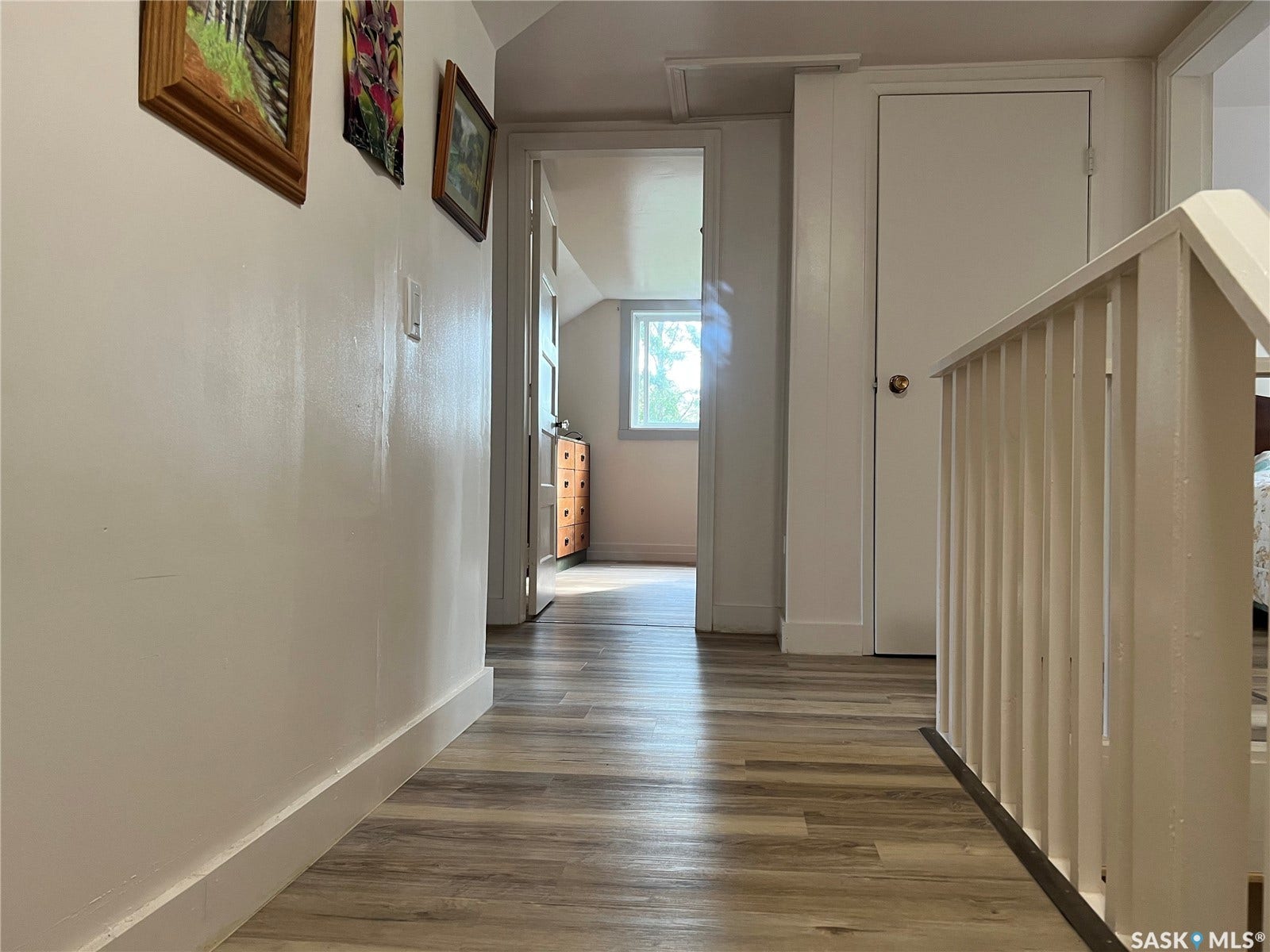 Wood-finish flooring throughout, white painted walls, and white trim