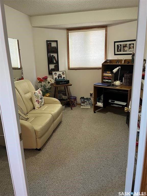 Carpeted room with a window featuring wood trim
