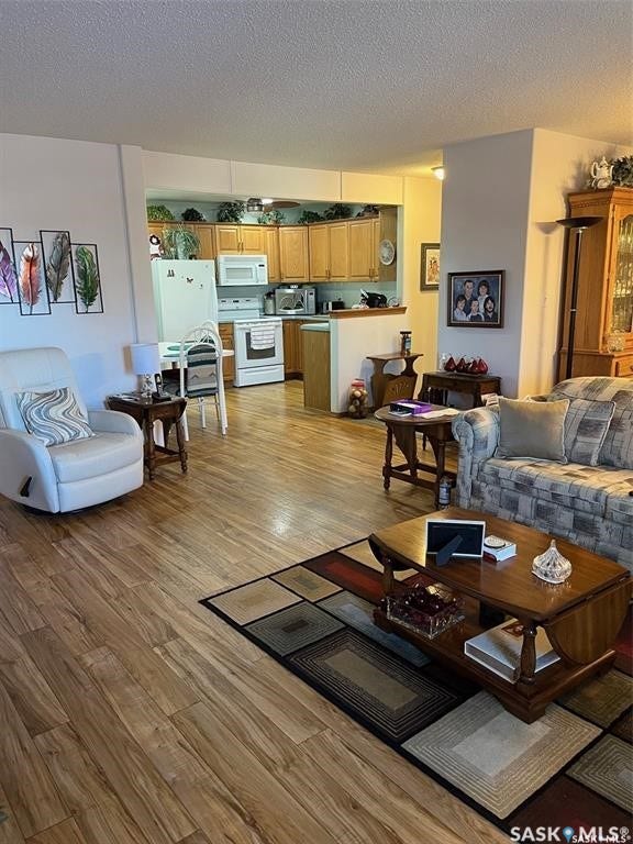 Wood-finish flooring throughout, with a recessed kitchen featuring wood cabinetry