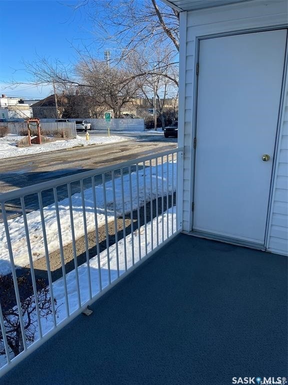 Exterior white siding, white door, and metal railing