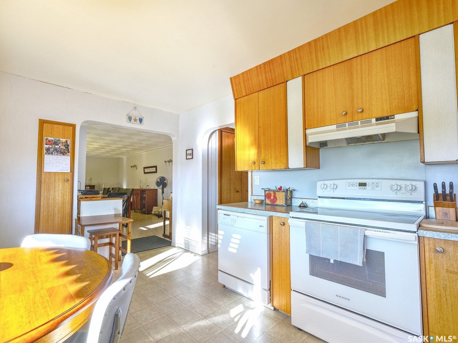Kitchen featuring wood-finish cabinetry, white electric range, and white dishwasher