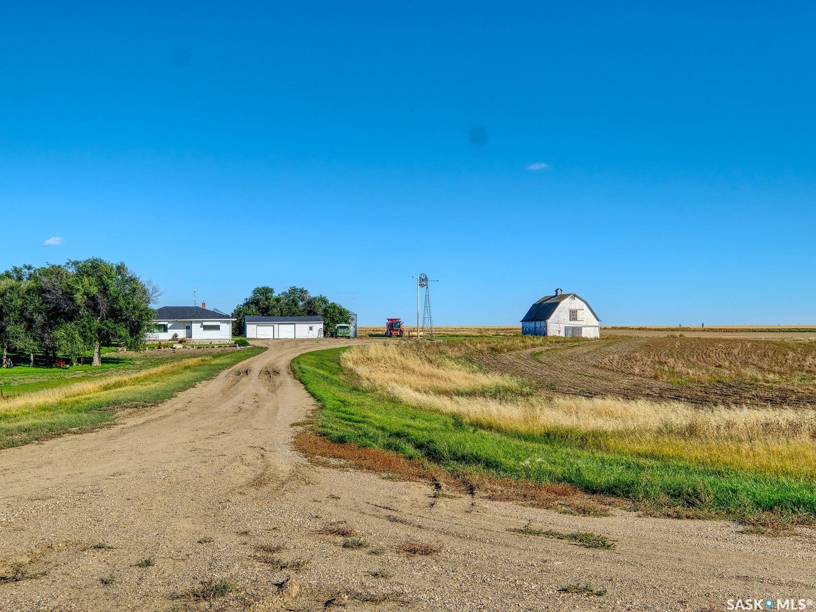 Gravel drive leading to a ranch-style house with an attached three-car garage