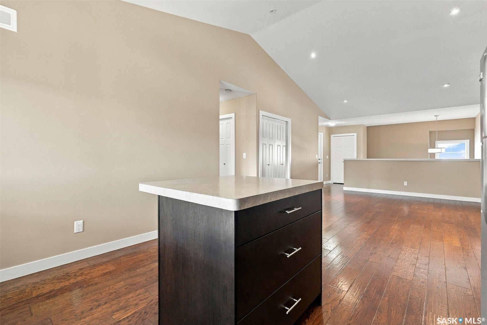 Engineered hardwood flooring, vaulted ceiling, recessed lighting, and a kitchen island