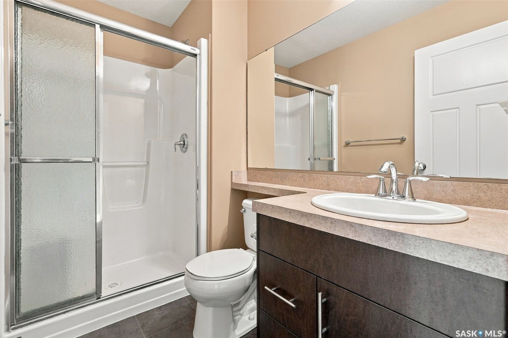 Walk-in shower with glass sliding doors and white surround