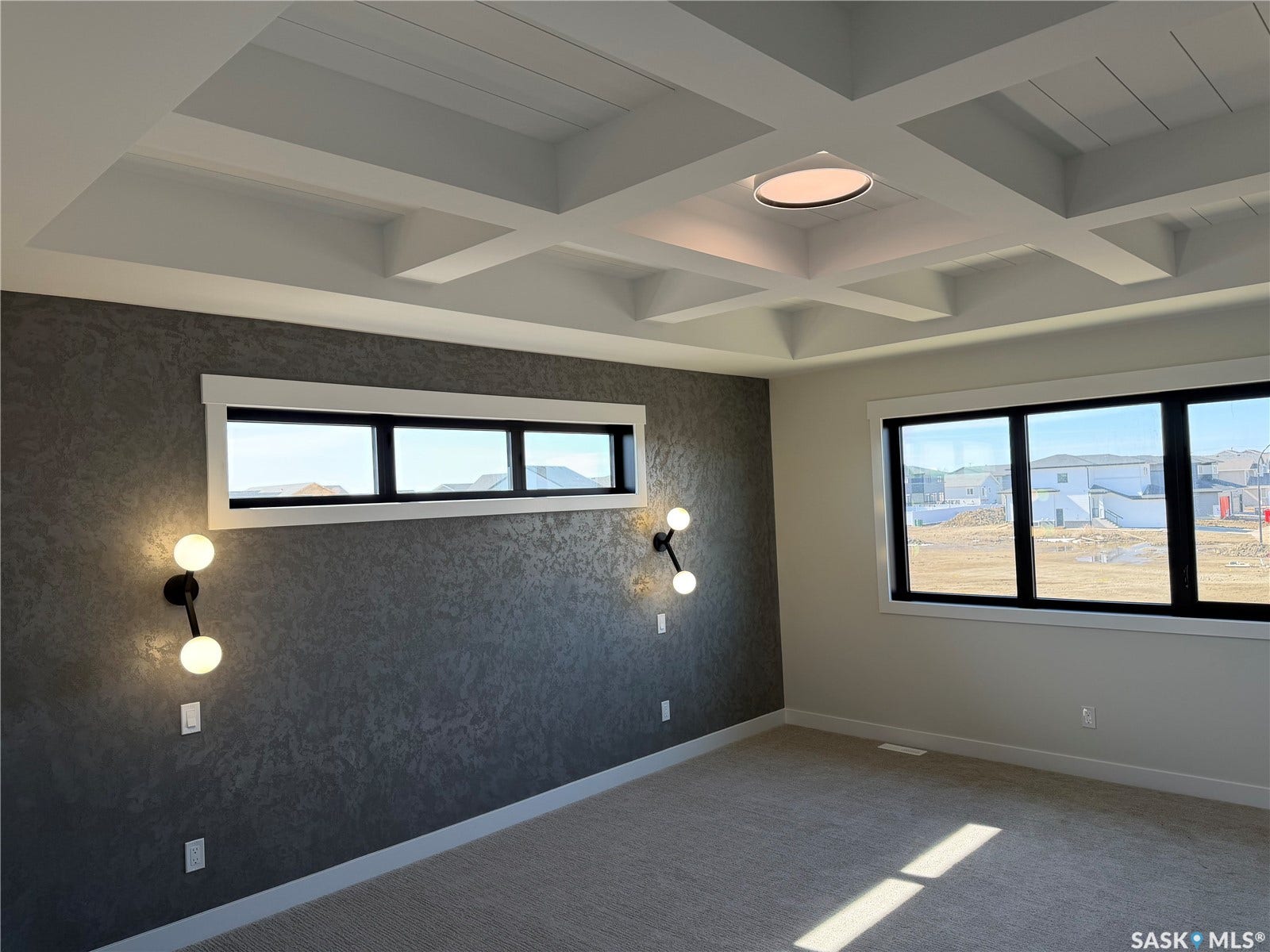 310 Traeger Manor, Saskatoon SK S7V 1Z4 Coffered ceiling with central flush-mount lighting, textured accent wall, and multiple black-framed windows