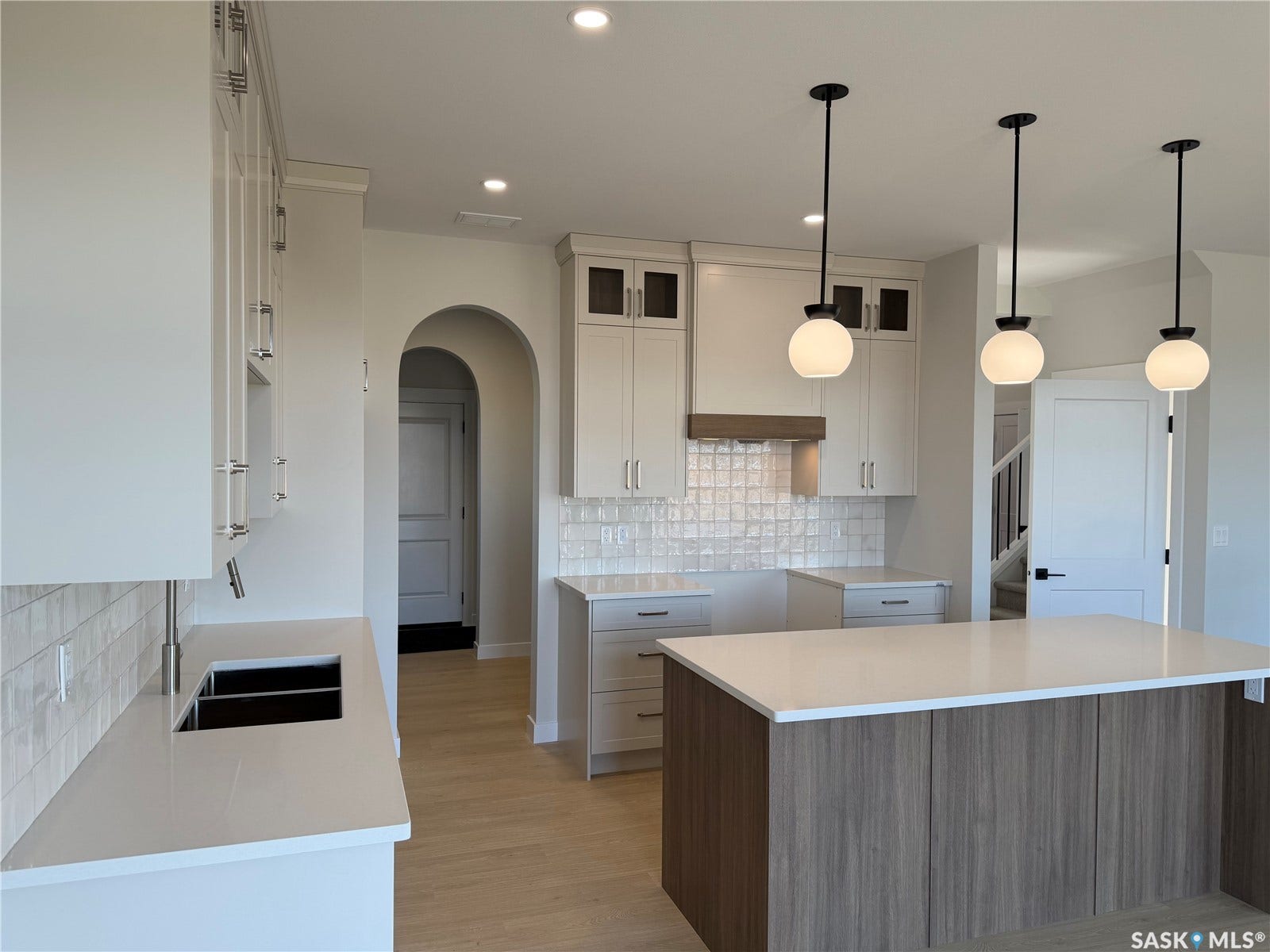 310 Traeger Manor, Saskatoon SK S7V 1Z4 White cabinetry with glass-front accents, light-toned countertops, and a white subway tile backsplash