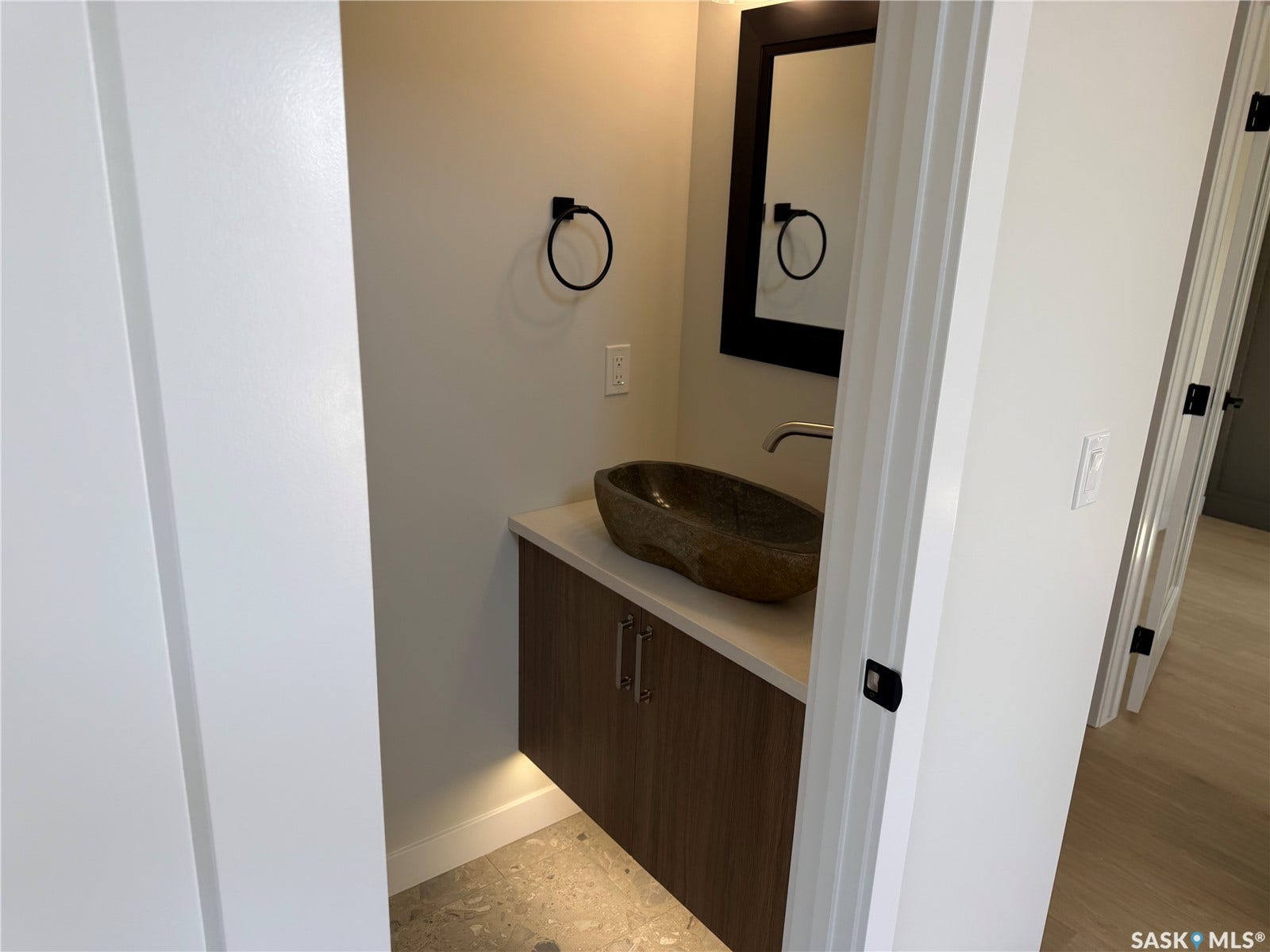 310 Traeger Manor, Saskatoon SK S7V 1Z4 Floating vanity with wood-finish cabinetry, stone vessel sink, and wall-mounted faucet