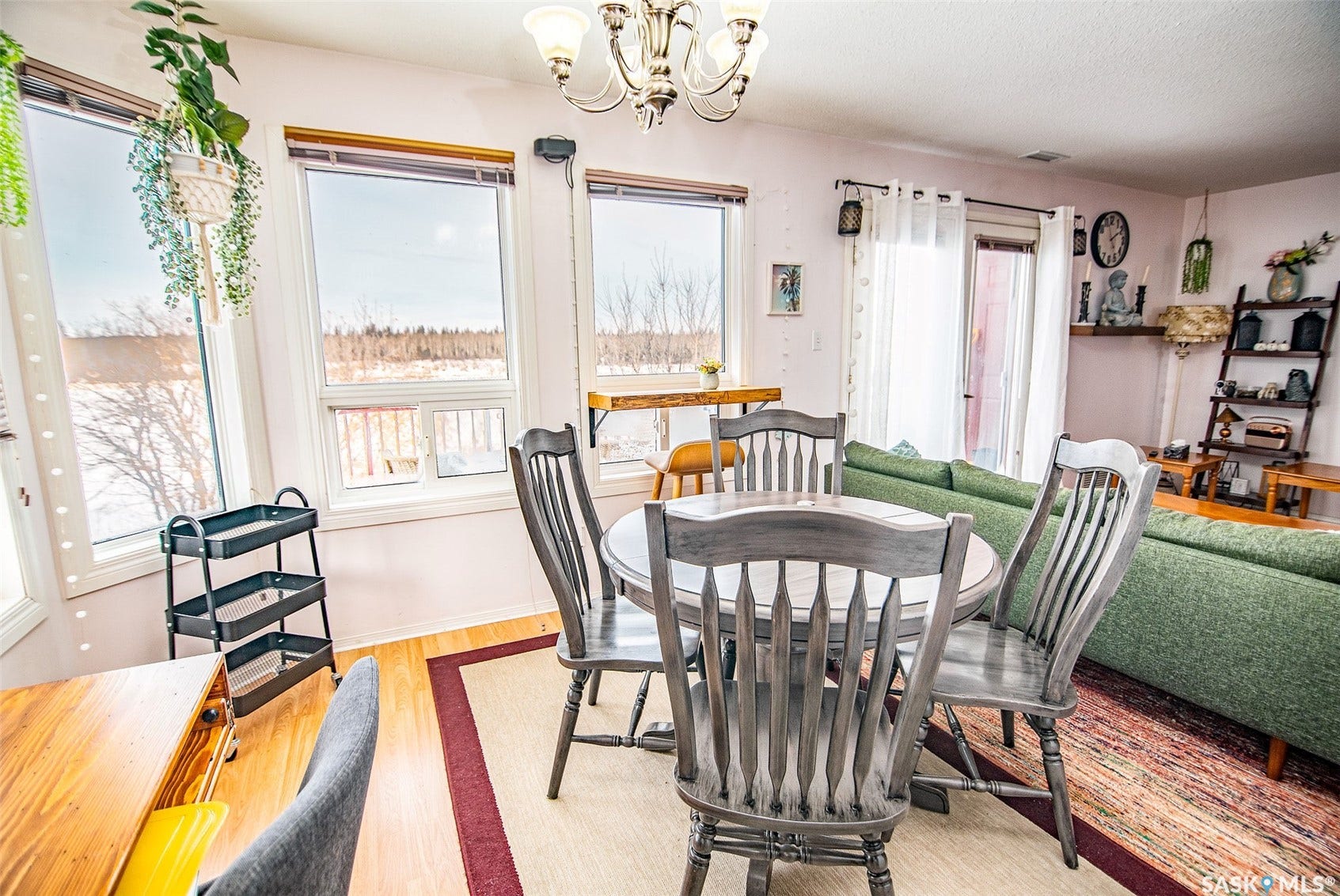 Expansive windows, wood-finish flooring, and a decorative ceiling fixture